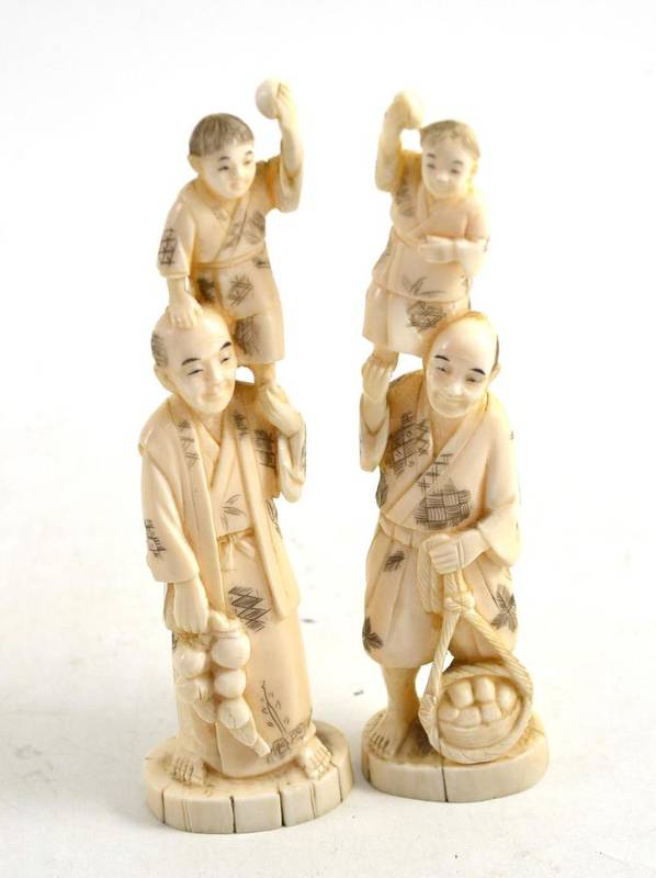 Lot 55 - A pair of Japanese marine ivory figures of gentlemen with boys on their shoulders
