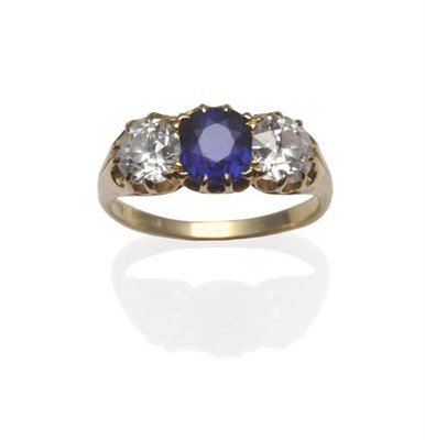 Lot 242 - A Sapphire and Diamond Three Stone Ring, the cushion cut sapphire flanked by an old brilliant...
