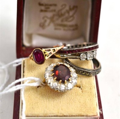 Lot 253 - A diamond three stone ring, a paste eternity ring, two red paste rings and a garnet cluster ring