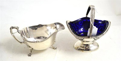 Lot 283 - A silver sauce boat and a silver swing handled sugar bowl with blue glass liner