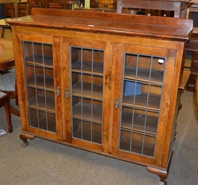 Lot 399 - A walnut bookcase enclosed by three leaded glazed doors