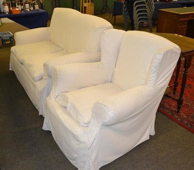 Lot 424 - A two seater settee and wing armchair upholstered in loose cream check