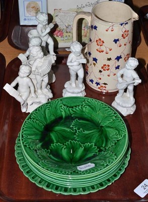 Lot 24 - Seven green glazed plates, four Italian cherub still vases and a pottery jug (12)