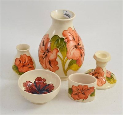 Lot 173 - Four Moorcroft coral Hibiscus pattern pieces including a vase, 20 cm high, a candlestick, a...