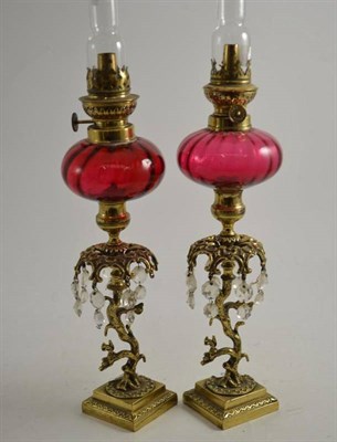 Lot 186 - A pair of oil lamps with tree and squirrel stems and cranberry forts