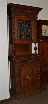 Lot 466 - A carved oak glazed bookcase on cupboard base