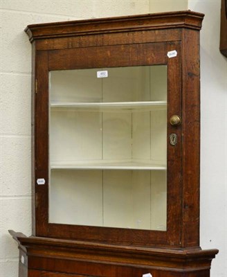 Lot 482 - A glazed oak hanging corner cupboard