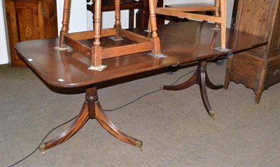 Lot 484 - A mahogany pedestal dining table with brass castors and extra leaf