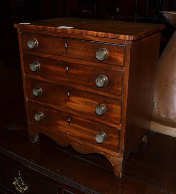 Lot 541 - A 19th century miniature mahogany chest of four graduated long drawers