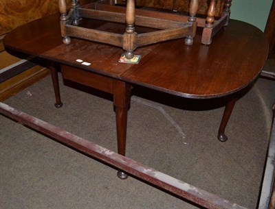 Lot 555 - A Georgian mahogany drop leaf table with paw feet