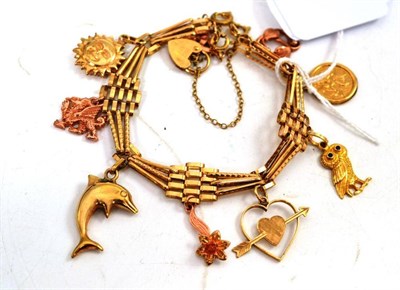 Lot 108 - A charm bracelet hung with nine charms including some Welsh gold