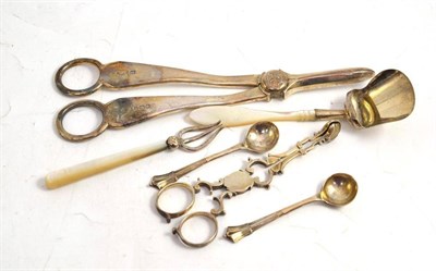 Lot 276 - A pair of grape scissors, sugar nips, scoop, date fork and two salt spoons