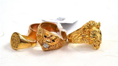 Lot 305 - A 9ct gold signet ring, two 9ct gold lion head rings and a stone set band ring