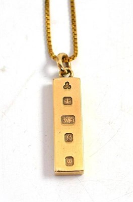 Lot 311 - A 9ct gold ingot on a 9ct gold box link chain