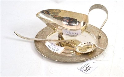 Lot 336 - Silver sauce boat and stand, maker's mark R.A.F, London and a sifting spoon (3)