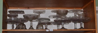 Lot 362 - A shelf of sixteen cake stands, two jelly moulds and a cream jug and sugar bowl