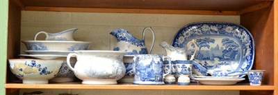 Lot 363 - A shelf of blue and white including meat plate, chamber pot, jug and bowl, and a tin glazed...