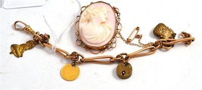 Lot 407 - A charm bracelet hung with a drilled one dollar coin and a cameo brooch