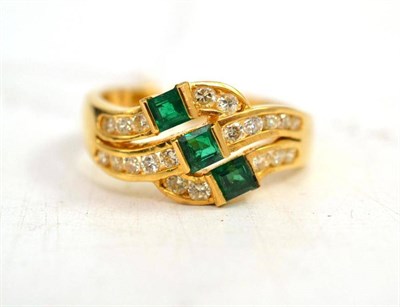 Lot 423 - An 18ct gold three stone emerald and diamond ring