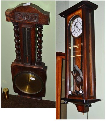 Lot 555 - A 19th century mahogany and walnut Vienna type wall clock and an oak cased barometer