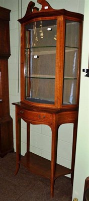 Lot 556 - An Edwardian satinwood bow fronted display cabinet on stand