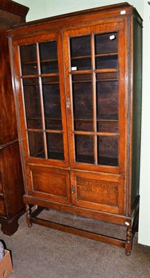 Lot 566 - A 1920's glazed oak display cabinet