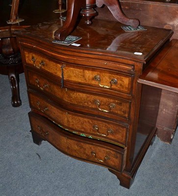 Lot 525 - A reproduction walnut serpentine chest of four drawers