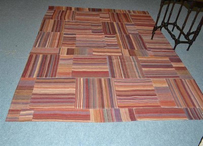 Lot 546 - A patchwork flat woven rug, comprised of polychrome bands, 237 by 181cm