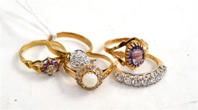 Lot 52 - A 9ct gold band ring with diamond set charms suspended, four 9ct gold dress rings, including an...