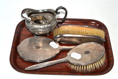 Lot 6 - A silver backed three piece vanity set, a single clothes brush, two silver napkin rings and a...