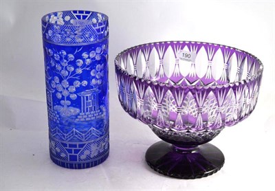Lot 190 - A large purple overlay cut glass pedestal bowl and a blue overlay cylindrical glass vase cut...