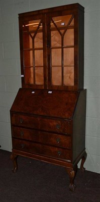 Lot 518 - A walnut bureau with later glazed top