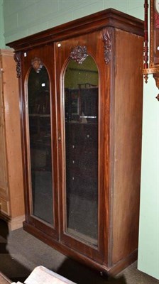 Lot 534 - A 19th century mahogany double wardrobe with a dome mirror panel to each door, with drawer and...