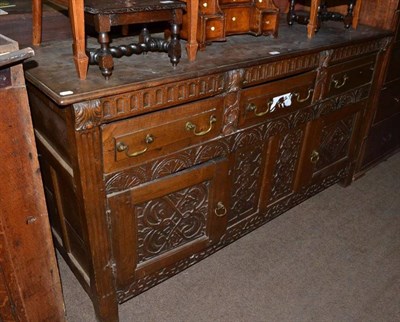 Lot 541 - An 18th century and later oak sideboard with carved decoration