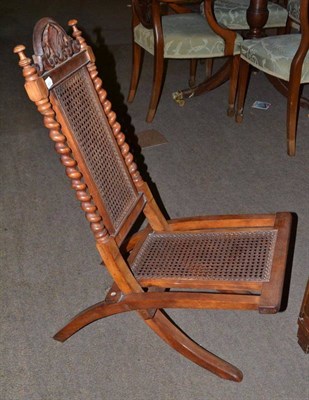 Lot 556 - A Victorian walnut framed folding side chair with cane back and seat