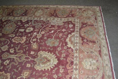 Lot 572 - Agra Design carpet, the rust field of palmettes enclosed by floral borders, 364cm by 275cm and...