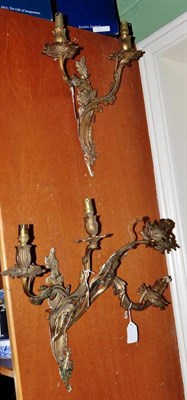 Lot 645 - Three gilt metal double branch wall sconces, of foliate cast form, approximately 36cm