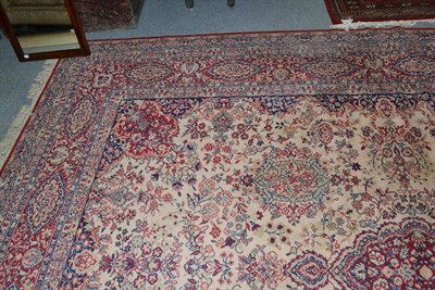 Lot 728 - A large cream ground rug with red floral decoration