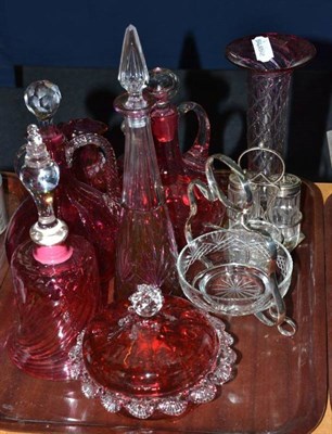 Lot 31 - A collection of cranberry glass including two carafes, bell, jugs, flask, a plated cruet and a...