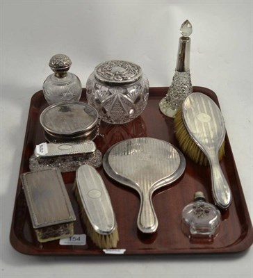 Lot 154 - A tray of silver items including silver topped scent bottle and jars, silver backed brushes etc