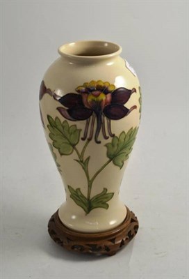 Lot 189 - A Moorcroft vase on a hardwood stand, 27cm high