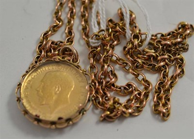 Lot 209 - A 1911 sovereign in glass fronted pendant on belcher chain