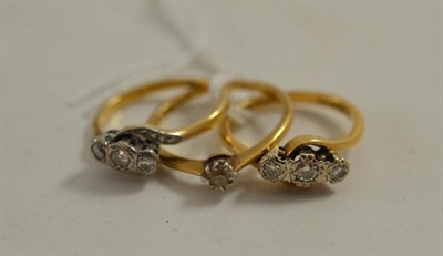 Lot 211 - Two diamond three stone rings and a diamond solitaire ring