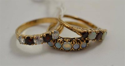 Lot 225 - A 9ct gold opal five stone ring, a 9ct gold garnet and opal five stone ring and a 9ct gold five...