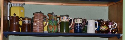 Lot 246 - A shelf of decorative ceramics including Majolica jug, copper lustre jugs, relief moulded jugs,...