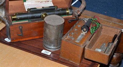 Lot 297 - A mahogany cased Dumpy level by Halden, an oak cased electric machine and a tin can containing...