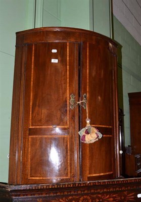 Lot 471 - A George III mahogany bow front hanging corner cupboard