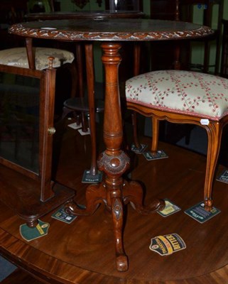 Lot 490 - A Victorian walnut tripod table with carved boarder