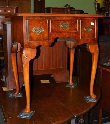 Lot 555 - A reproduction walnut lowboy