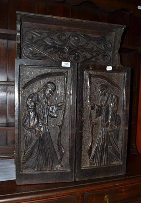 Lot 595 - A 19th century carved oak wall cupboard, the doors decorated with figures